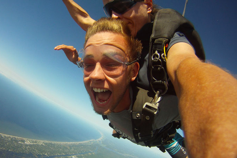 Tandem skydiver with blonde hair and tandem skydiving instructor jump near Myrtle Beach