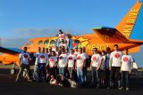 Group of skydivers posting in front of Beechcraft King Air with custom pop art paint job