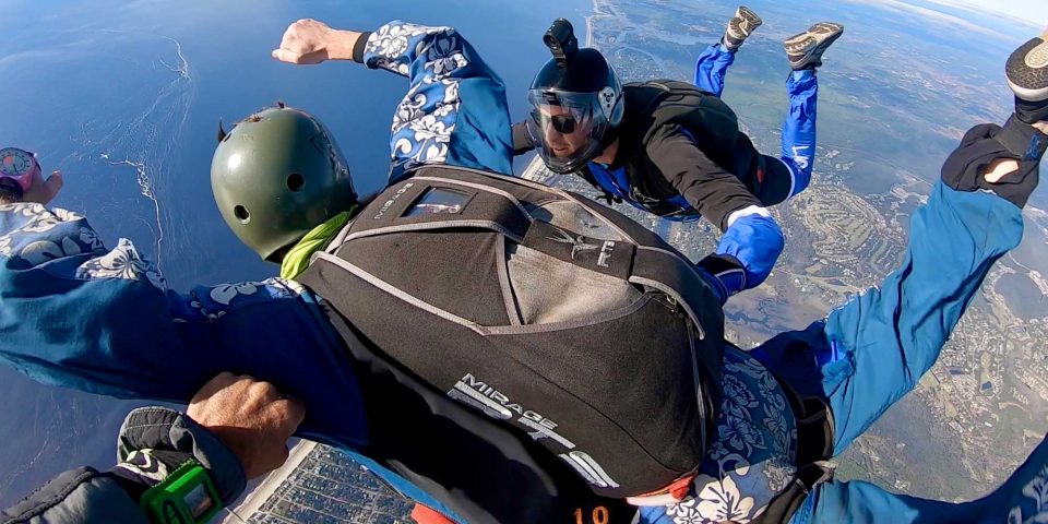 Accelerated freefall student accompanied by instructor on main side and reserve side