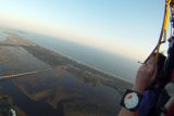 A tandem student steers the parachute with toggles over Oak Island,NC coast