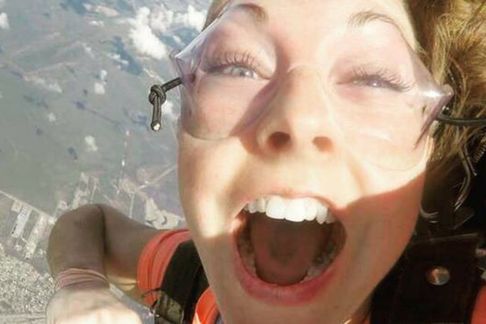 Close up on excited open mouthed face of skydiving student with long eyelashes