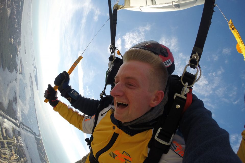 Tandem skydiver with blonde hair and tandem skydiving instructor jump near Myrtle Beach