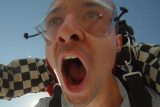 Male tandem skydiving student with eyes and mouth wide open