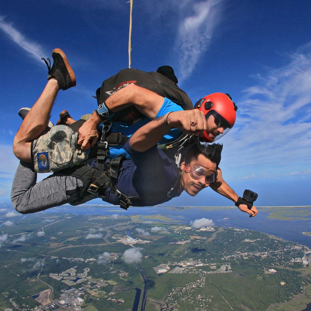 Outside photo of tandem skydiver and instructor in freefall over Wilmington, NC